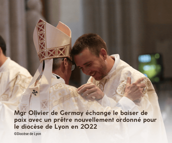 Mgr Olivier de Germay échange le baiser de paix avec un prêtre nouvellement ordonné pour le diocèse de Lyon en 2022